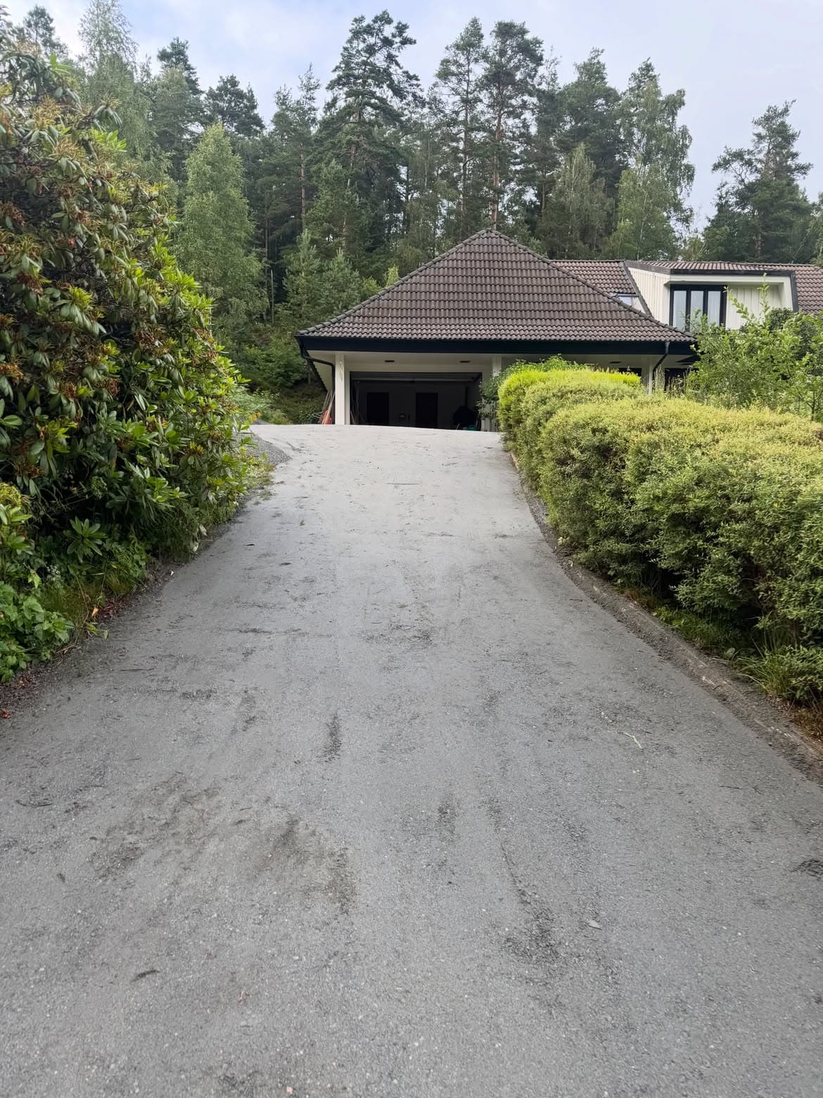 Uppfräschad grusinfart med nytt slitlager upp mot garaget