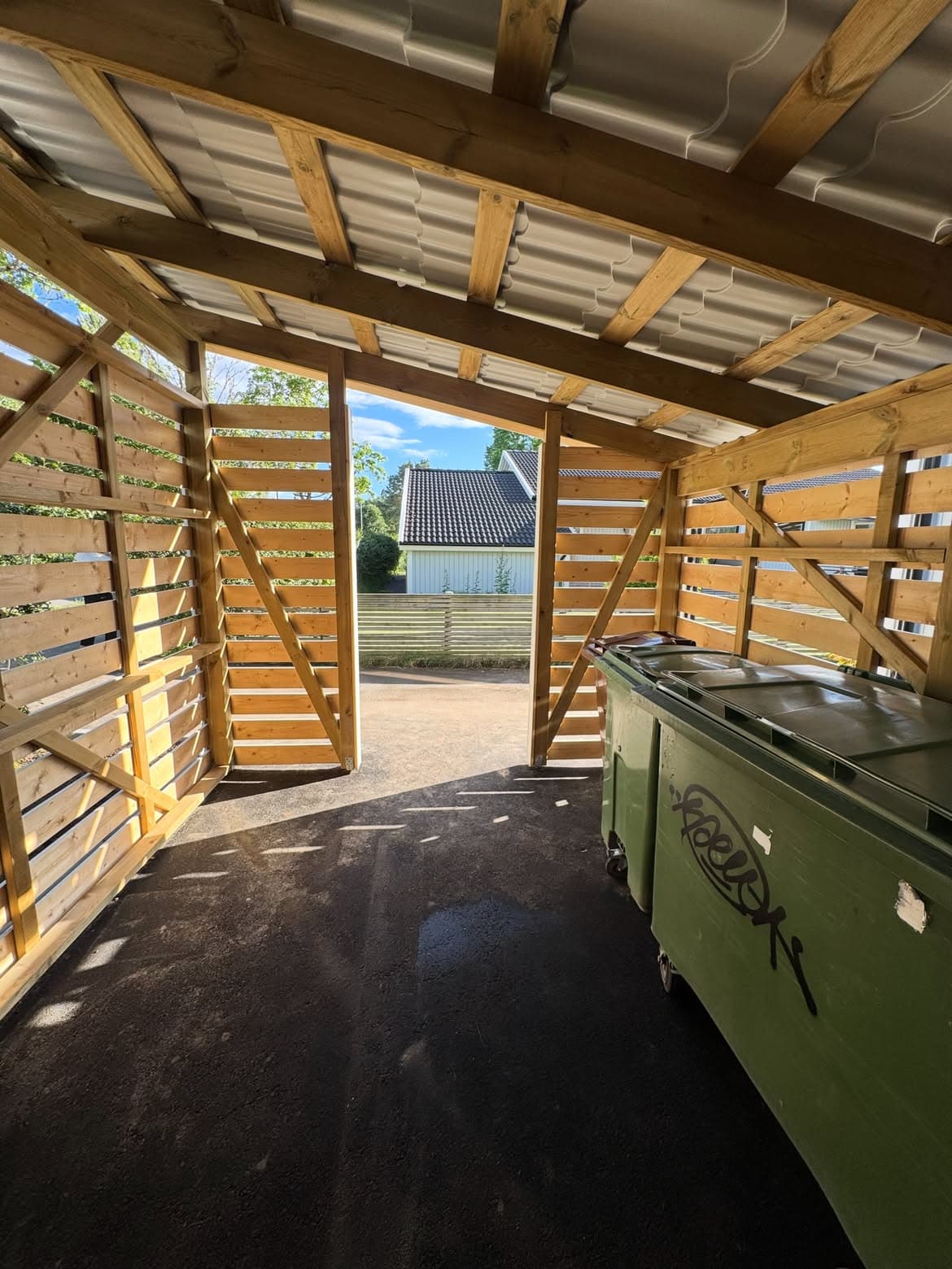 Sopkärl på plats inne i rummet bakom ribbverket